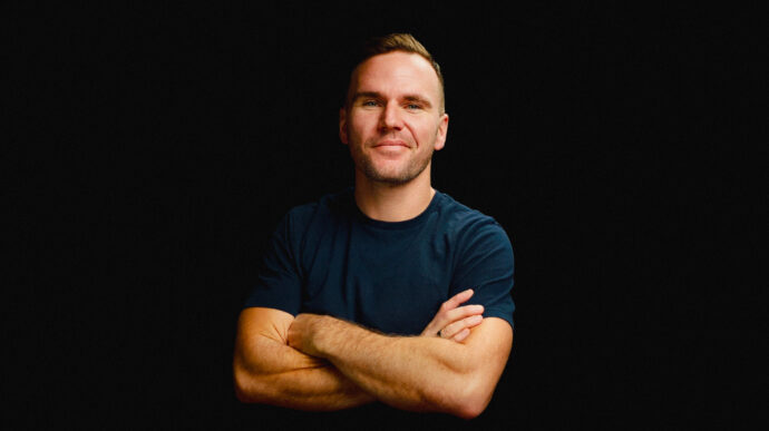 brad hussey, blue shirt, black background